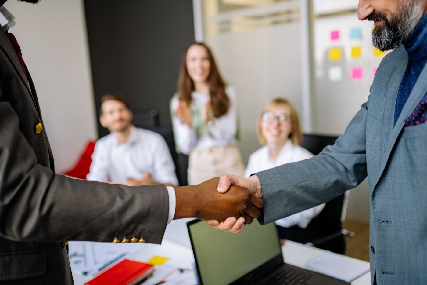 Two colleagues shaking hands in a bright office