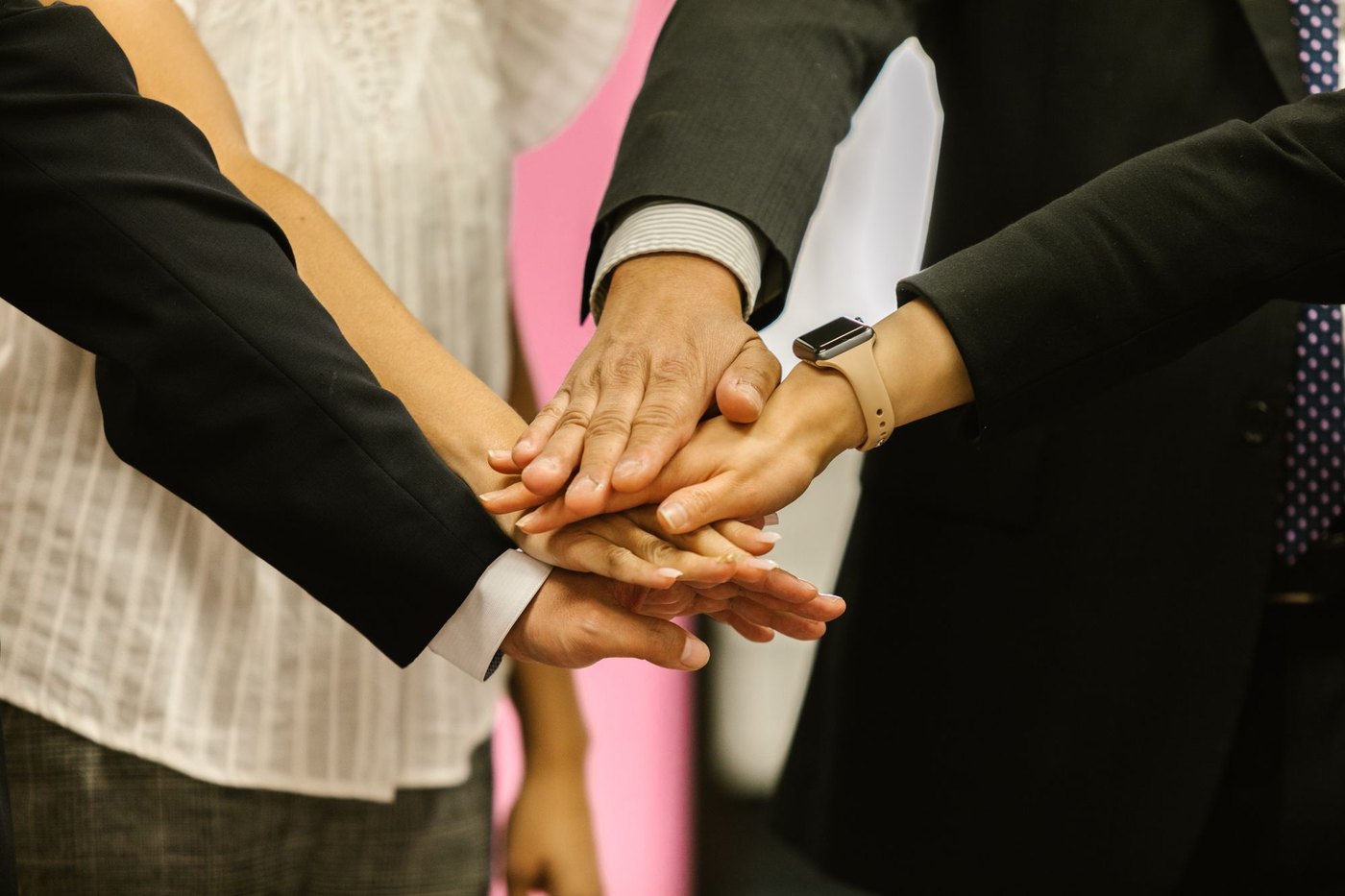 Colleagues stacking their hands together as a team